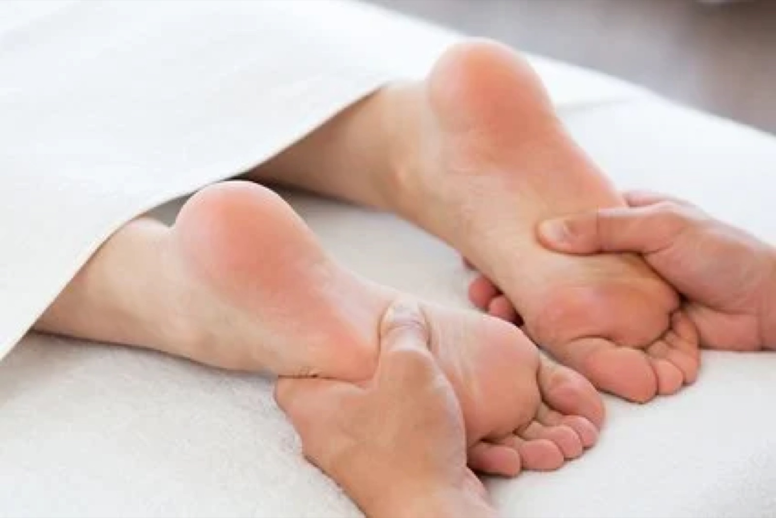 Foot massage, a person receiving a massage on the soles of the feet.