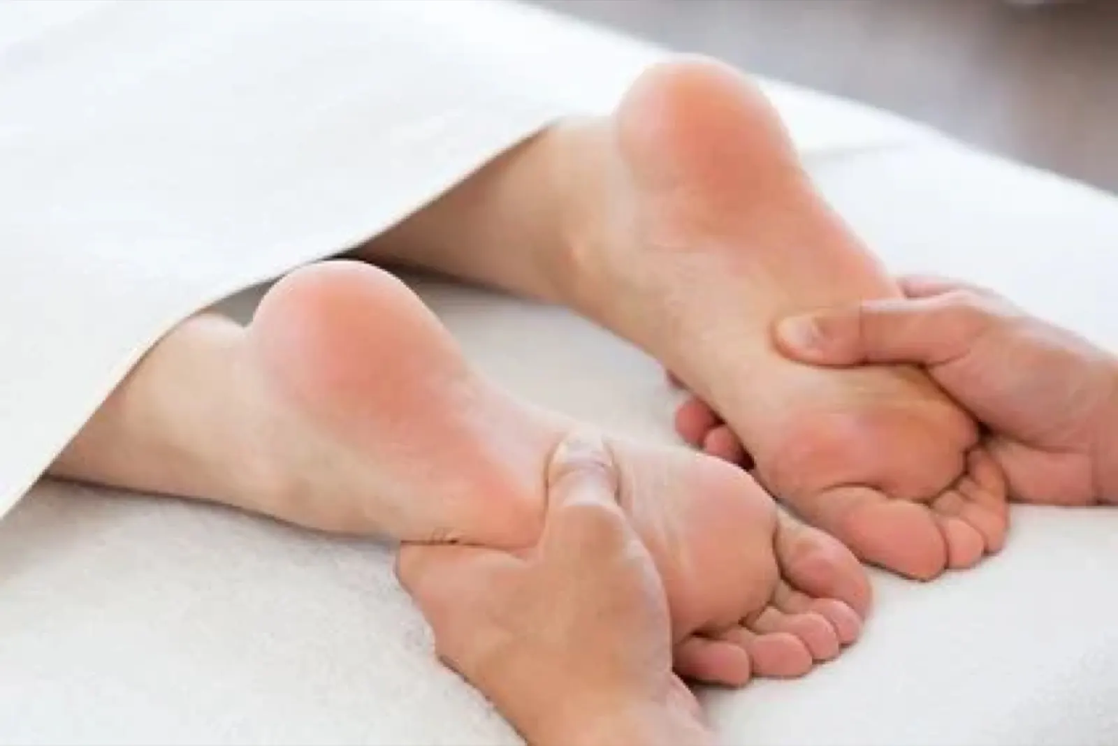 Fußmassage, eine Person erhält eine Massage an den Fußsohlen.