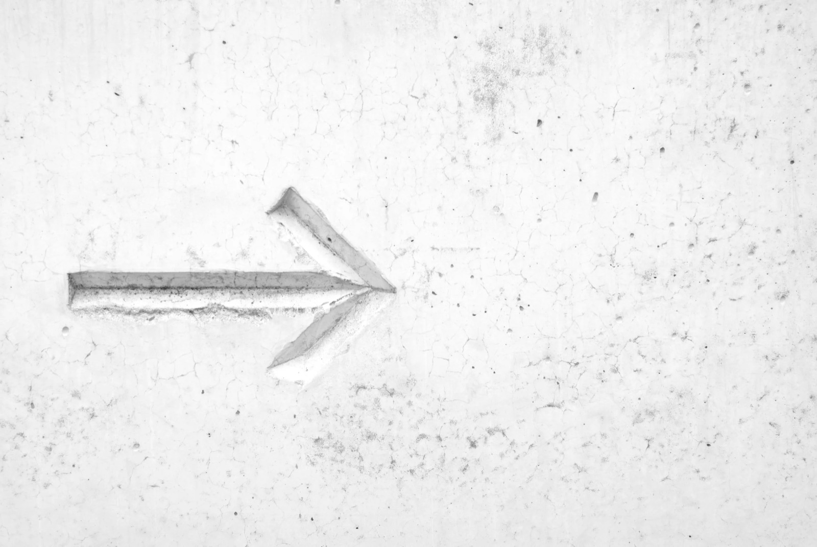 Gray wall with a milled arrow marking pointing to the left.