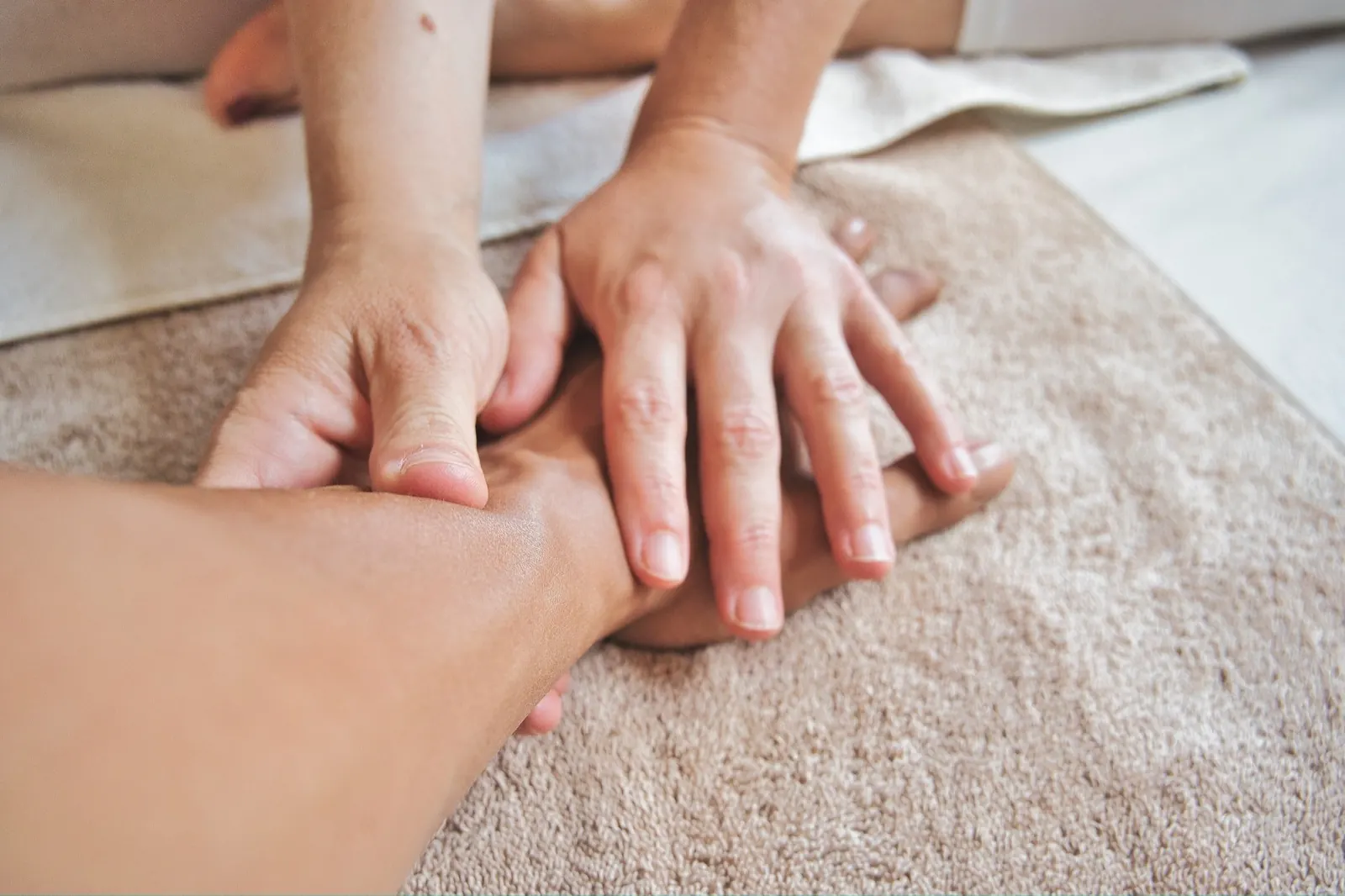 Masseur gibt einer Person eine Rückenmassage auf einer Liege.